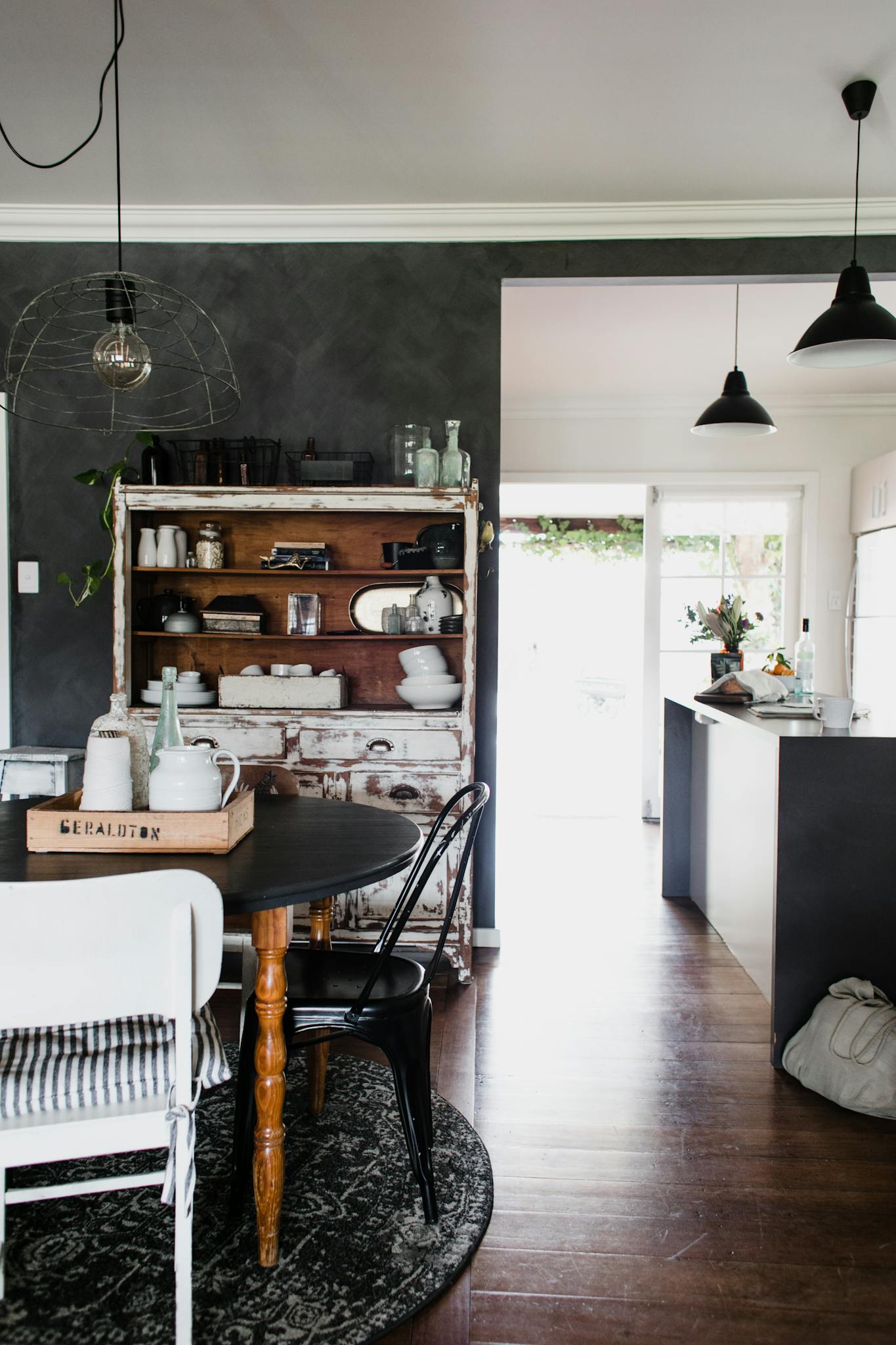 A beautifully designed rustic dining room featuring vintage furniture, natural light, and elegant decor.